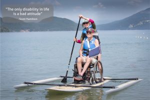 an adaptive paddle board with a wheelchair on top and a quote: The only disability in life is a bad attitude - Scott Hamilton