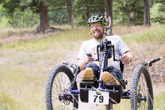 man rides a handcycle on a trail during the 12 & 24 Hours of Flathead