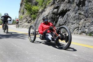 cyclist on hand cycle rides down the going to the sun road