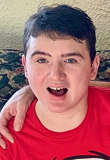 Aidan is smiling at the camera