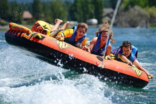 photo of three people tubing in the water