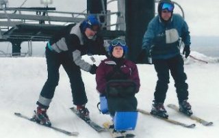 Jane Lopp offloading from the chairlift with volunteers