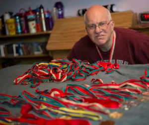 volunteer poses with medals