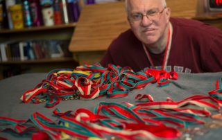 volunteer poses with medals